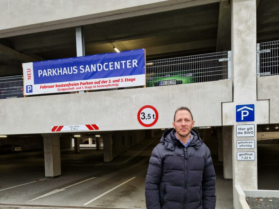 Prokurist Herr Schmidt vor dem Sandcenter Parkhaus – Auch im Februar 2024 profitieren Autofahrer von kostenfreiem Parken auf den Ebenen 2 und 3.
