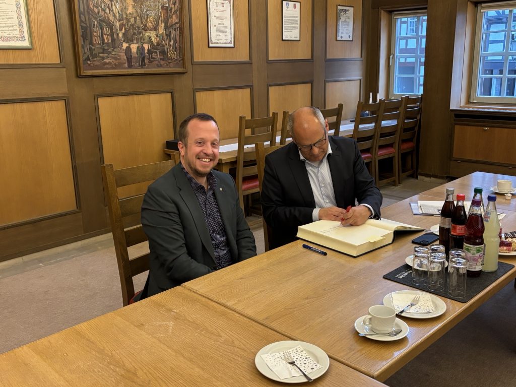 Bürgermeister Timo Riedemann (links) und Innenminister Prof. Dr. Roman Poseck bei der feierlichen Eintragung ins Goldene Buch der Stadt Melsungen im Rahmen der Übergabe des Förderbescheids „Sicherheit bei Veranstaltungen“.