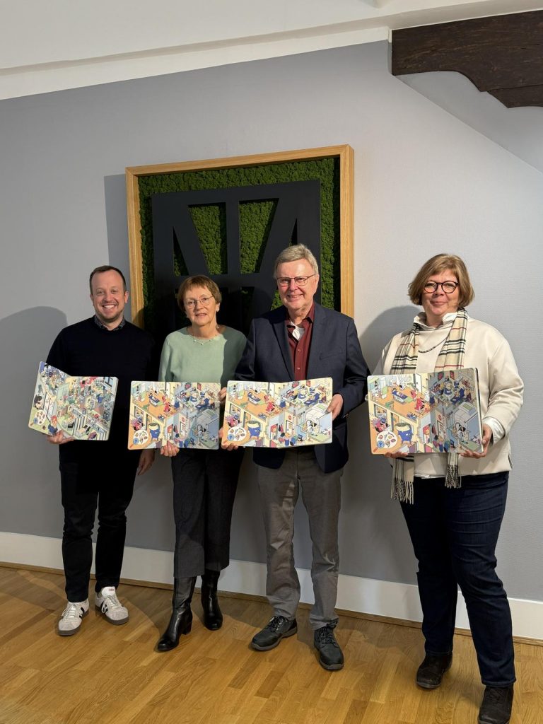Bürgermeister Timo Riedemann und die Kinder- und Familienbeauftragte Nicole Funck gratulieren der Helga und Heinrich Holzhauer Stiftung zum Stiftungsjubiläum: Peter und Roswitha Vaupel übergeben 100 Exemplare des neuen Wimmelbuchs „Was passiert hier? Eine Reise durch die Klinik“, das künftig kostenfrei an Kinder und Familien in Melsungen verteilt wird.