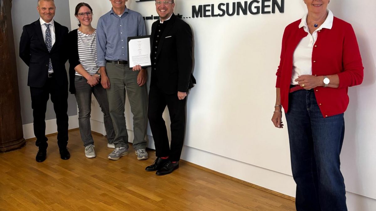Gemeinsam für mehr Solarenergie in Melsungen: Darius Maloschek, Sarah Link, Thomas Flügge, Bürgermeister Timo Riedemann und Erste Stadträtin Ulrike Hund präsentieren vor der Melsungen-Silhouette die Kooperationsvereinbarung zwischen der Stadt Melsungen und der cdw Stiftung. Mit der geplanten 360-kWp-Photovoltaikanlage am Waldschwimmbad und einer Anschubfinanzierung von rund 500.000 Euro wird der Grundstein für weitere Klimaschutzprojekte in Melsungen gelegt.