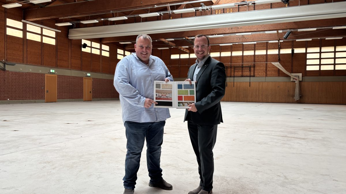 Von links: Manuel Schmelz vom Immobilienmanagement der Stadt Melsungen und Bürgermeister Timo Riedemann in der Stadtsporthalle. Der alte Hallenfußboden ist bereits entfernt – in Kürze wird der neue Sportboden aufgebracht.