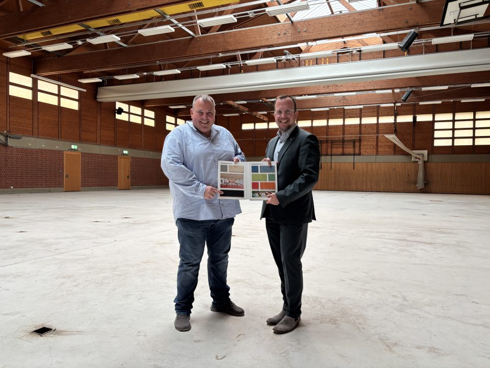 Von links: Manuel Schmelz vom Immobilienmanagement der Stadt Melsungen und Bürgermeister Timo Riedemann in der Stadtsporthalle. Der alte Hallenfußboden ist bereits entfernt – in Kürze wird der neue Sportboden aufgebracht.