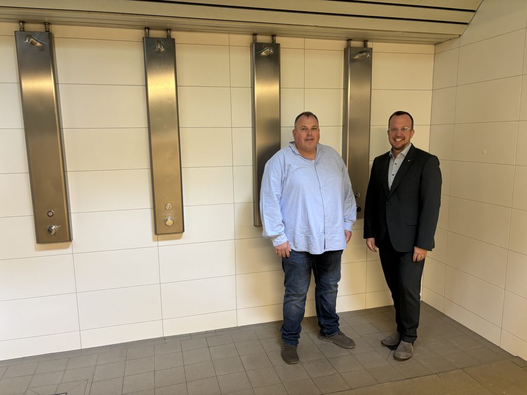 Von links Manuel Schmelz vom städtischen Immobilienmanagement und Bürgermeister Timo Riedemann in den modernisierten Sanitär- und Duschbereichen der Stadtsporthalle.